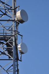 Communications tower with antennas against a blue sky