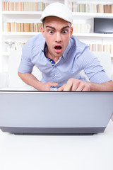 surprised man pointing at computer monitor with shock