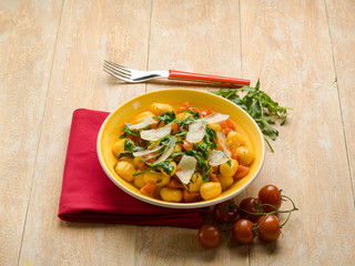 gnocchi with arugula tomato and parmesan cheese