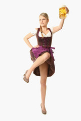 Frau im Dirndl mit Bier springt in die Luft