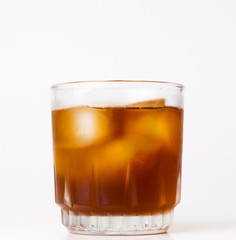 glass with ice tea full with ice cubes on white background