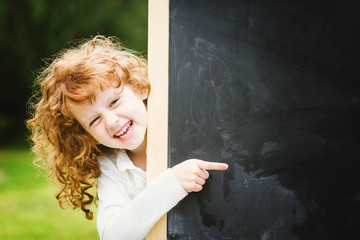 Back to school. Girl at blackboard. Educational concept. Place f