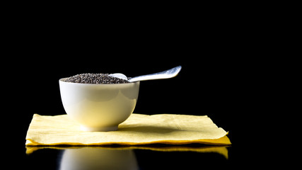 Bowl of healthy chia seeds on a black table
