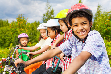 Smiling African guy in helmet with friends behind