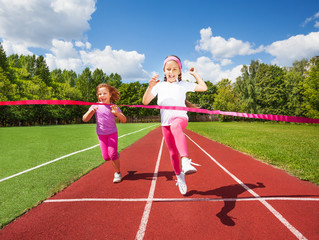 Girl runs and reaches ribbon excited to win