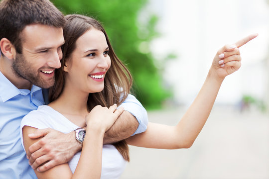 Happy Young Couple Pointing Finger