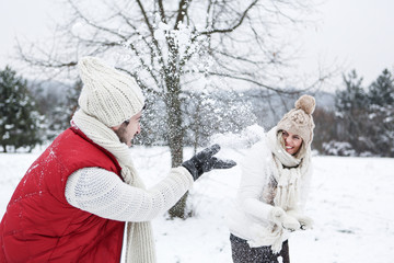 Paar bei Schneeballschlacht im Winter