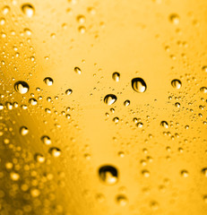 golden water drops on glass
