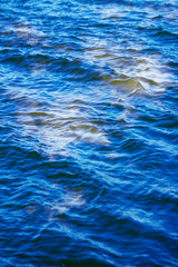 sky with clouds reflected on the water surface with waves