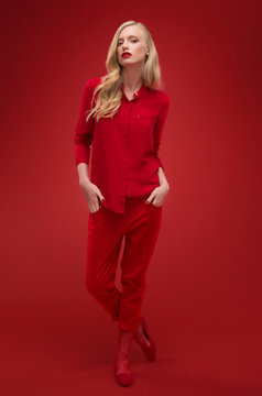 Stylish woman in red suit in studio