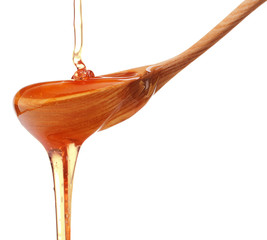 Honey dripping from a wooden honey dipper isolated on white back