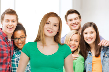 group of smiling teenagers over classroom