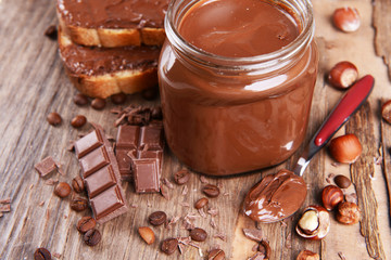 Sweet chocolate cream in jar on table close-up