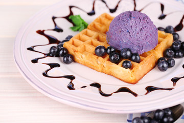 Tasty belgian waffles with ice cream on wooden table