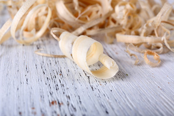 Wood shavings on white wooden background closeup