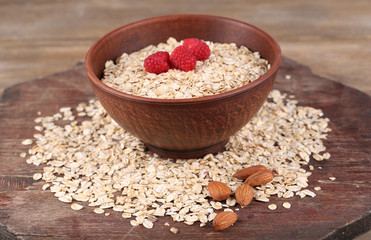 Big brown bowl with oatmeal and berries on a wooden table