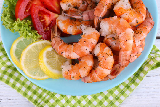 Plate of fresh boiled prawns with tomatoes, lettuce, lemon and