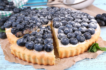 Tasty homemade pie with blueberries on wooden table