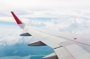 Wing of an airplane flying above the clouds