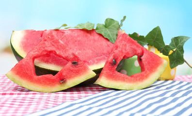 Fresh slices of watermelon on table, on blue background