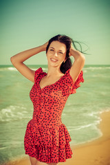 Young girl in red dress on the sea