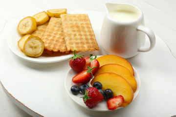 Delicious breakfast with milk, cookies and fruits