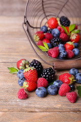 Ripe sweet different berries in metal basket,