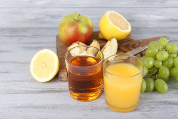 glasses of juice with fresh fruits on grey wooden table