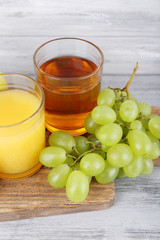 glasses of juice with fresh fruits on grey wooden table
