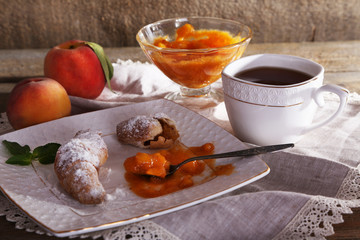 still life with cup of tea and apricot jam on wooden table
