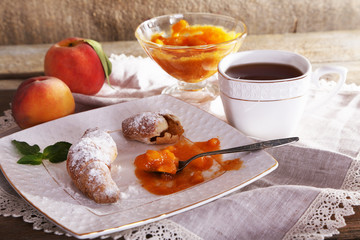 still life with cup of tea and apricot jam on wooden table