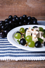 tasty salad with grape and cheese on wooden table