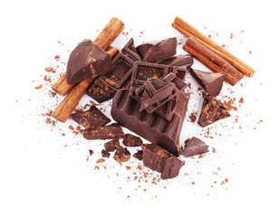 Cracked chocolate bar with spices isolated on white