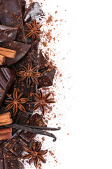 Cracked chocolate bar with spices on white background