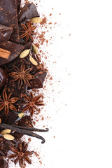 Cracked chocolate bar with spices on white background