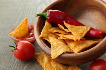 Tasty nachos, red tomatoes and chili pepper in color bowl