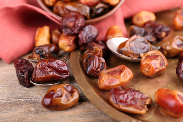 Tasty dates fruits on old metal tray, on wooden background