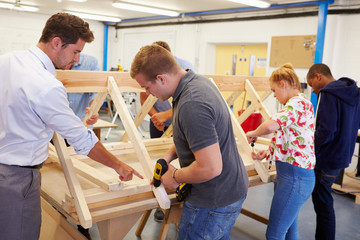 Teacher Helping College Students Studying Carpentry