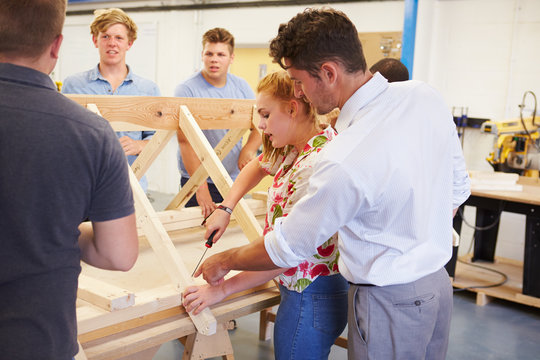 Teacher Helping College Students Studying Carpentry