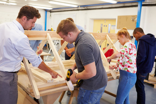 Teacher Helping College Students Studying Carpentry
