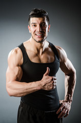 Fototapeta premium Muscular man posing in dark studio