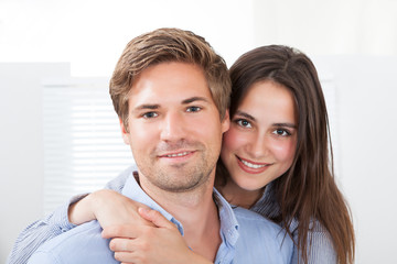 Man Giving Piggyback Ride To Woman At Home