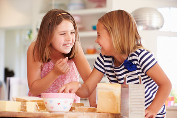Girls Eating Ingredients Whilst Making Cheese On Toast