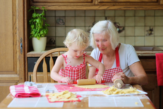 Grandmother and granddaughter preparing cookies in the kitchen