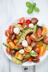 Salad with grilled avocado, tomatoes and mozzarella, above view