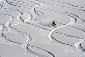 Fototapeta na wymiar Mountain skier go down on powder snow.