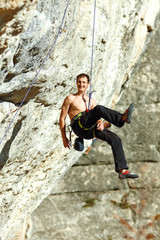 Rock climber climbing up a cliff