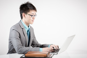 Asian business man using laptop computer isolated on white backg