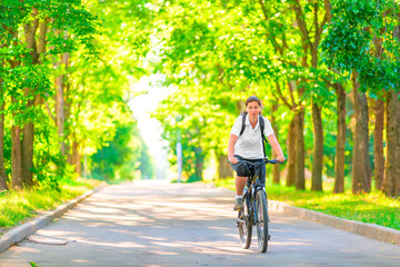 Fototapeta premium young girl on a bicycle in a park in the early morning