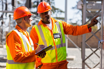 industrial electricians taking machine readings